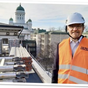 Immo Aakkula Kansallisarkiston katolla työmaasuojavarusteissa, taustalla Tuomiokirkko